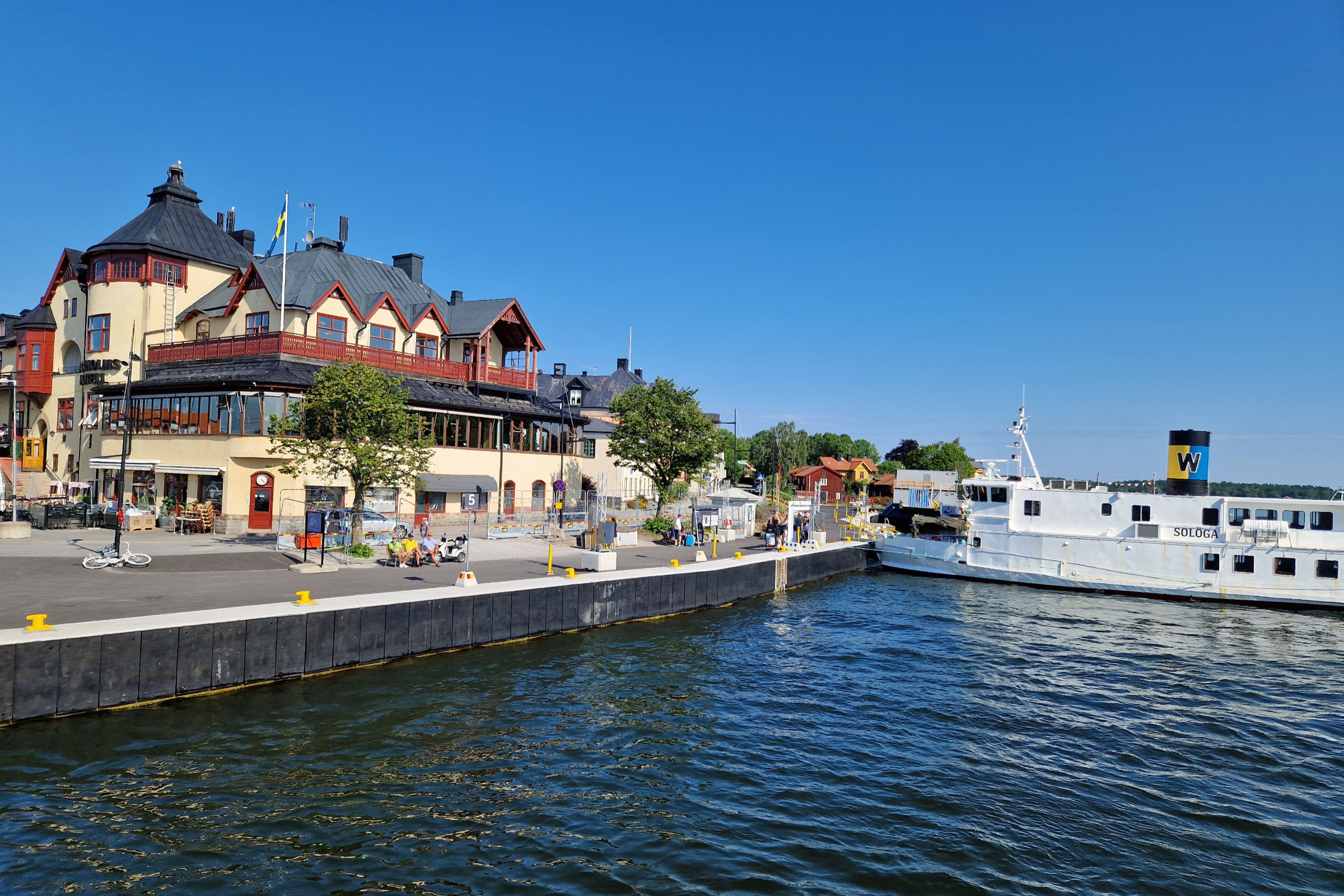 Vaxholm harbour on a sunny summer day with a Waxholmsbolaget ship at the docks.